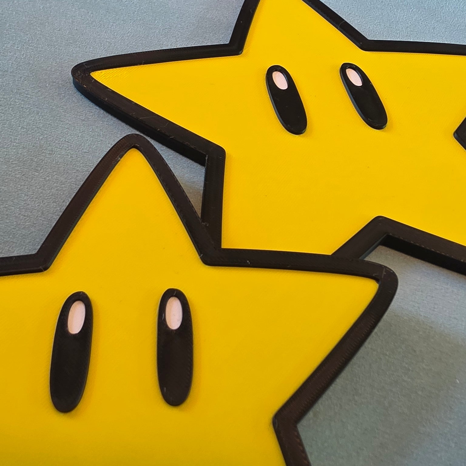 Close-up of small and large Super Mario star inspired gaming wall signs